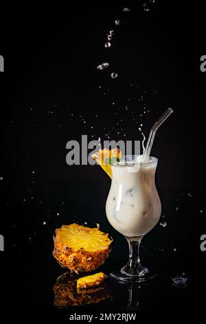 Traditioneller karibischer Sommer-Pina Colada-Cocktail mit Rum, Kokosmilch und Ananasgarnierung auf schwarzem Hintergrund Stockfoto