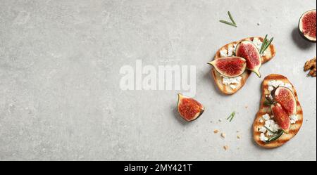 Bruschettas mit Feigen und Käse auf einem hellen Tisch, flach liegend. Platz für Text, Bannerdesign Stockfoto