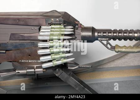 Ein Band mit großen Kugeln wird in ein Maschinengewehr geladen. Großkaliber-Munitionsgürtel. Stockfoto