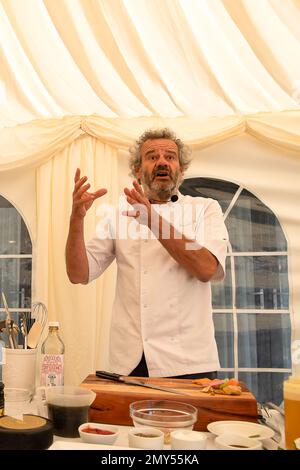 BILDER ABLEGEN. 4. Februar 2023. Nach der Covid-19-Pandemie ließ Mark Hix eine Terrassenfläche im Freien vor seinem Oyster and Fish House in Lyme Regis, Dorset, bauen. Die Ratsmitglieder des Stadtrats von Lyme Regis haben Hix mitgeteilt, dass sein „illegaler“ Terrassenbereich im Freien nun bis Ende März 2023 stillgelegt werden muss. Mehr als 4000 Menschen haben einen Wunsch unterschrieben, dass es bleibt. Sein Restaurant überblickt den berühmten Cobb in Lyme Bay, der Schauplatz des französischen Lieutentant-Frauenfilms mit Meryl Streep und Jeremy Irons war. Tetbury, Großbritannien. 1. Juni 2022. Kochvorführung des berühmten Küchenchefs Mark Hix Stockfoto