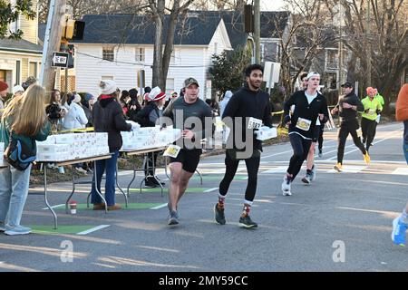 Raleigh, NC, USA, 4. Februar 2023, schnappen sich Läufer Kisten Krispy Kreme Doughnuts auf halber Strecke eines 5 km langen Sprints vom Campus der North Carolina State University. Die alljährliche Krispy Kreme Challenge wurde 2004 unter Freunden zum ersten Mal als „Mut“ geführt und wurde schnell zu einer Benefizveranstaltung für das Kinderkrankenhaus des UNC. Der Kursrekord von 28:29 wurde 2020 mit einem Tempo von 5:41/Meile gesetzt, einschließlich Zeit zum Essen von Donuts. Bei landesweiter Exposition lautet das Motto „2.400 Kalorien, 12 Donuts, 5 Meilen, 1 Stunde“. Credit D Guest Smith / Alamy Live News Stockfoto