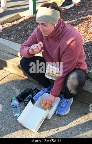 Raleigh, NC, USA, 4. Februar 2023, laufen Läufer auf halber Strecke eines 5 km langen Sprints vom Campus der North Carolina State University ein Dutzend Krispy Kreme Doughnuts herunter. Die alljährliche Krispy Kreme Challenge wurde 2004 unter Freunden zum ersten Mal als „Mut“ geführt und wurde schnell zu einer Benefizveranstaltung für das Kinderkrankenhaus des UNC. Der Kursrekord von 28:29 wurde 2020 mit einem Tempo von 5:41/Meile gesetzt, einschließlich Zeit zum Essen von Donuts. Bei landesweiter Exposition lautet das Motto „2.400 Kalorien, 12 Donuts, 5 Meilen, 1 Stunde“. Credit D Guest Smith / Alamy Live News Stockfoto