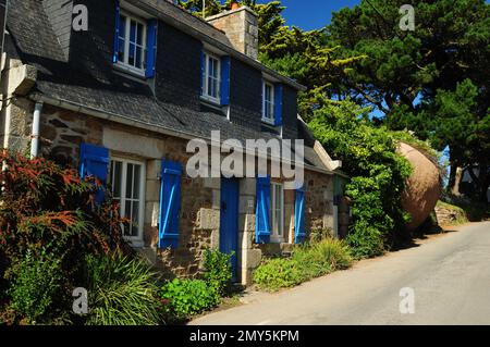 Wunderschönes antikes Landhaus mit blauen Fensterläden in Ploumanach Bretagne Frankreich an Einem wunderschönen sonnigen Sommertag mit klarem blauen Himmel Stockfoto