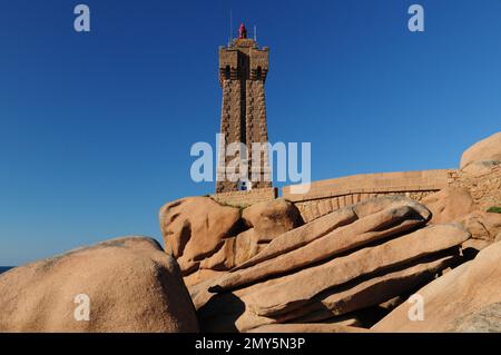 Der Leuchtturm von Ploumanach über den riesigen Felsbrocken an der wunderschönen Red Rock Coast Bretagne France an Einem wunderschönen sonnigen Sommertag mit klarem blauen Himmel Stockfoto