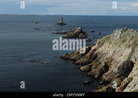 Blick von Pointe Du Raz auf den Leuchtturm Phare De La Vielle in Bretagne, Frankreich an Einem wunderschönen sonnigen Sommertag mit ein paar Wolken am Himmel Stockfoto