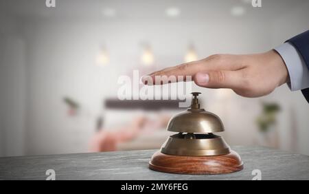 Mann läutet Hotelglocke auf unscharfem Hintergrund, Schließung Stockfoto