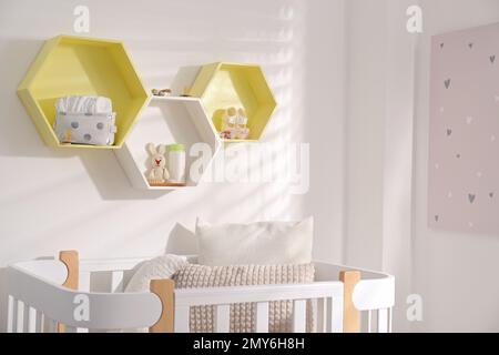 Sechseckige Regale an der weißen Wand im Kinderzimmer. Innendesign Stockfoto