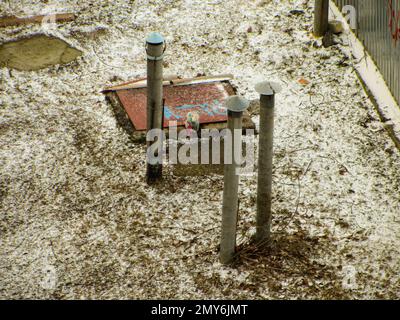 Entlüftungsrohr ragt aus dem Boden heraus. Rohrbelüftung des Kellers. An einem Sommertag ragt am Flussufer eine rostige Pfeife aus dem Boden. Ventilati Stockfoto