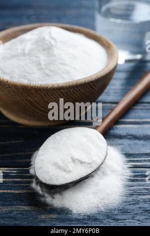 Backpulver in Schüssel auf blauem Holztisch Stockfoto