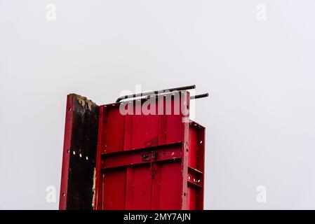 Stahlschalungen und Bewehrungsstäbe für Säulen, die zum Ausgießen von Beton bereit sind. Rote Farbe Stockfoto