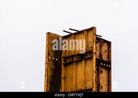 Stahlschalungen und Bewehrungsstäbe für Säulen, die zum Ausgießen von Beton bereit sind. Gelbe Farbe Stockfoto