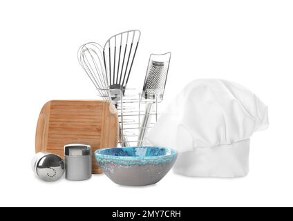 Set mit verschiedenen Kochutensilien und Chefhut auf weißem Hintergrund Stockfoto