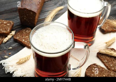Tassen mit köstlichem KWass, Stacheln und Brot auf dem Tisch Stockfoto