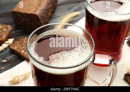 Tassen mit köstlichem KWass, Stacheln und Brot auf dem Tisch Stockfoto