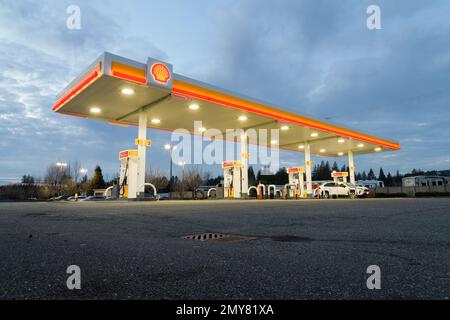 Sultan, WA, USA - 01. Februar 2023; Shell-Tankstellenpumpen mit beleuchteter Markise und Schild Stockfoto