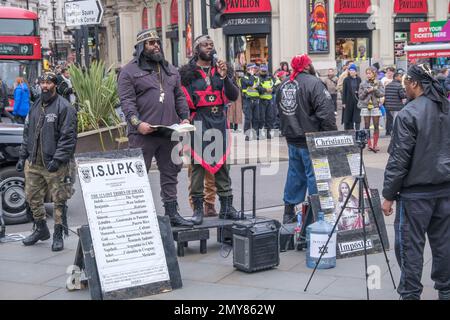 London, Großbritannien. 4. Februar 2023 Mitglieder der ISUPK predigen im Piccadilly Circus. Sie sind Mitglieder einer in den USA ansässigen schwarzen, supramakistischen, extremen religiösen Sekte und lesen Texte aus der König-James-Version der Bibel, die sie behaupten, dass Schwarze aus der Karibik zusammen mit den Indianern in Nord- und Südamerika Nachkommen der zwölf Stämme Israels sind. Die israelische Schule für universelles praktisches Wissen ist eine von mehreren ähnlichen schwarz-hebräischen israelischen Sekten. Peter Marshall/Alamy Live News Stockfoto