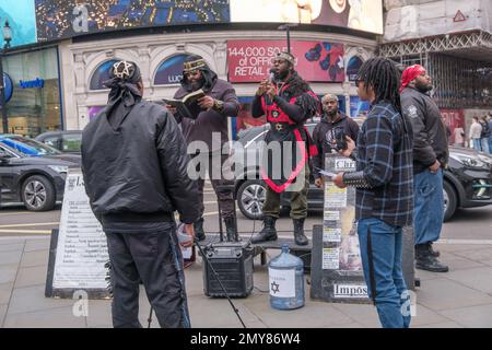 London, Großbritannien. 4. Februar 2023 Mitglieder der ISUPK predigen im Piccadilly Circus. Sie sind Mitglieder einer in den USA ansässigen schwarzen, supramakistischen, extremen religiösen Sekte und lesen Texte aus der König-James-Version der Bibel, die sie behaupten, dass Schwarze aus der Karibik zusammen mit den Indianern in Nord- und Südamerika Nachkommen der zwölf Stämme Israels sind. Die israelische Schule für universelles praktisches Wissen ist eine von mehreren ähnlichen schwarz-hebräischen israelischen Sekten. Peter Marshall/Alamy Live News Stockfoto