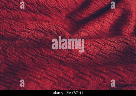 Wunderschöne Strickstruktur aus rotem Pullover. Nahaufnahme des Hintergrunds. Stockfoto