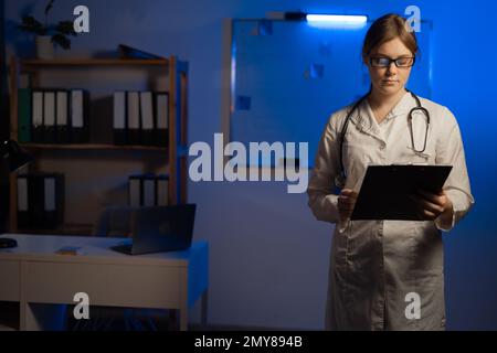 Ärztin für Frauenmedizin hält Klemmbrett und ist bereit, den Patienten zu untersuchen. Medizinische Versorgung, Versicherung, Verschreibung, Papierarbeit oder Karrierekonzept. Stockfoto