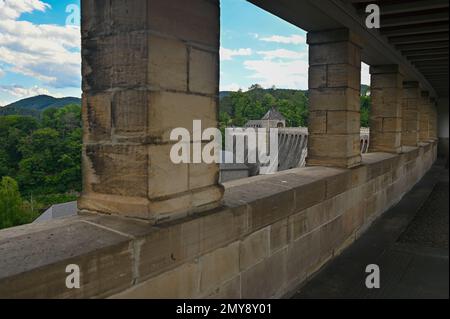 Verschwommene Säulen am Edertal-Staudamm mit Blick auf einen Teil der Mauer, die Edertalsperre mit blauem Himmel und Wolken, in Hessen, Deutschland Stockfoto