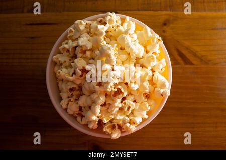 Goiania, Goias, Brasilien – 04. Februar 2023: Eine Schüssel voller Popcorn auf einem Holztisch. Stockfoto