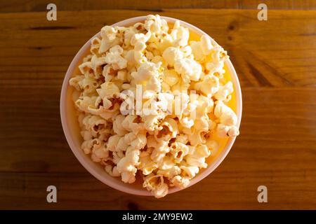 Goiania, Goias, Brasilien – 04. Februar 2023: Eine Schüssel voller Popcorn auf einem Holztisch. Stockfoto