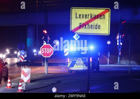 Leverkusen, Deutschland. 04. Februar 2023. Die Polizei sperrt eine Straße hinter einem Ortsschild in Leverkusen ab. Am Samstag Mittag wurde während der Bauarbeiten im Stadtteil Leverkusen in Opladen eine 5 Tonnen schwere Bombe entdeckt. Seither hat der Explosivstoffbeseitigungsdienst zusammen mit der öffentlichen Ordnung die notwendigen Schließungen des Gebiets im Umkreis von 400 Metern um den Entdeckungsort durchgeführt, wie die Stadt angekündigt hat. Kredit: David Young/dpa/Alamy Live News Stockfoto