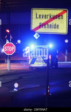 Leverkusen, Deutschland. 04. Februar 2023. Die Polizei sperrt eine Straße hinter einem Ortsschild in Leverkusen ab. Am Samstag Mittag wurde während der Bauarbeiten im Stadtteil Leverkusen in Opladen eine 5 Tonnen schwere Bombe entdeckt. Seither hat der Explosivstoffbeseitigungsdienst zusammen mit der öffentlichen Ordnung die notwendigen Schließungen des Gebiets im Umkreis von 400 Metern um den Entdeckungsort durchgeführt, wie die Stadt angekündigt hat. Kredit: David Young/dpa/Alamy Live News Stockfoto