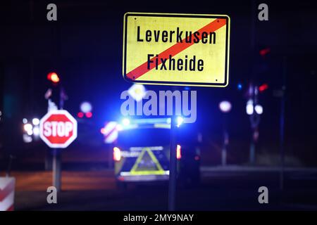 Leverkusen, Deutschland. 04. Februar 2023. Die Polizei sperrt eine Straße hinter einem Ortsschild in Leverkusen ab. Am Samstag Mittag wurde während der Bauarbeiten im Stadtteil Leverkusen in Opladen eine 5 Tonnen schwere Bombe entdeckt. Seither hat der Explosivstoffbeseitigungsdienst zusammen mit der öffentlichen Ordnung die notwendigen Schließungen des Gebiets im Umkreis von 400 Metern um den Entdeckungsort durchgeführt, wie die Stadt angekündigt hat. Kredit: David Young/dpa/Alamy Live News Stockfoto