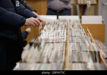 Vinyl-Sammler, der sich die Fahrkarten ansieht. Ein erwachsener Mann, der Lieblingsmusik für einen analogen Plattenspieler im Musikgeschäft kauft, konzentriert sich auf die Hände Stockfoto