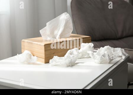 Gebrauchte Papiertücher und Holzhalter auf dem Tisch im Innenbereich Stockfoto