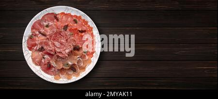 Verschiedene Fleischstücke, Schinken und Würstchen auf Holzhintergrund. Banner Stockfoto