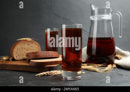 Köstlicher Kavass, Stacheln und Brot auf dem schwarzen Tisch Stockfoto