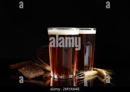 Köstlicher Kavass, Brot und Stacheln auf schwarzem Hintergrund Stockfoto