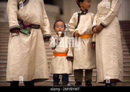 A Mongolian boy eats ice cream as he stands with his family at Sukhbaatar Square in Ulaanbaatar, Sunday, July 10, 2016. Mongolians will celebrate the anniversary of Genghis Khan's march to world conquest on July 11 with the annual Naadam sports festival featuring traditional Mongolian events including wrestling, archery, and horse racing. (AP Photo/Mark Schiefelbein)