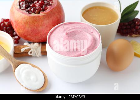 Glas aus Gesichtsmaske, Granatapfel und frischen Zutaten auf weißem Hintergrund. Natürliche organische Kosmetika Stockfoto