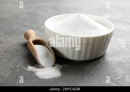 Backpulver in Schüssel auf grauem Tisch Stockfoto