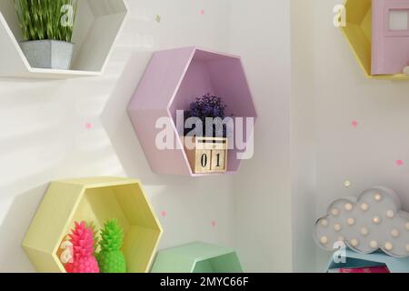 Sechseckige Fachböden an weißen Wänden. Innendesign Stockfoto