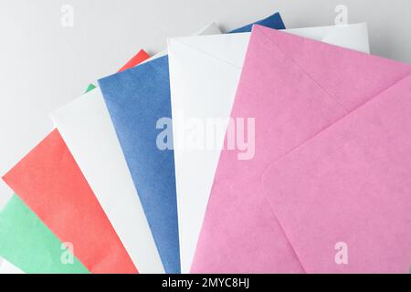 Farbige Papierumschläge auf hellem Hintergrund, Draufsicht Stockfoto