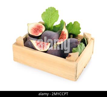 Ganze und geschnittene, leckere, frische Feigen mit grünen Blättern in einer Holzkiste auf weißem Hintergrund Stockfoto