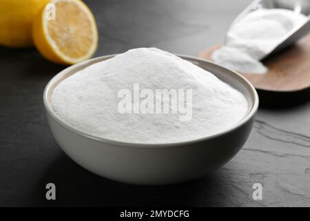 Backpulver in Schüssel auf schwarzem Tisch Stockfoto