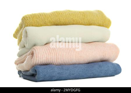 Stapel verschiedener warmer Pullover, isoliert auf weiß Stockfoto