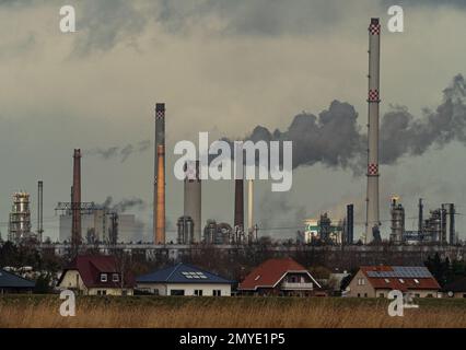 30. Januar 2023, Brandenburg, Schwedt/Oder: 29.01.2023, Schwedt/Oder. Die Schornsteine der Raffinerie PCK und anderer Unternehmen im Industriepark Schwedt erheben sich an einem wolkigen Januartag in den Himmel. Wohngebäude sind im Vordergrund zu sehen. Foto: Wolfram Steinberg/dpa Foto: Wolfram Steinberg/dpa Stockfoto