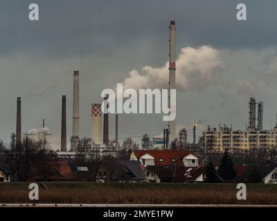 30. Januar 2023, Brandenburg, Schwedt/Oder: 29.01.2023, Schwedt/Oder. Die Schornsteine der Raffinerie PCK und anderer Unternehmen im Industriepark Schwedt erheben sich an einem wolkigen Januartag in den Himmel. Wohngebäude sind im Vordergrund zu sehen. Foto: Wolfram Steinberg/dpa Foto: Wolfram Steinberg/dpa Stockfoto