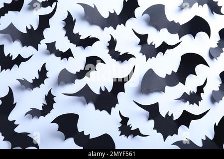 Viele schwarze Fledermäuse auf weißem Hintergrund, flach liegend. Halloween-Dekor Stockfoto