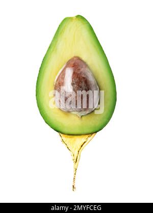 Avocadoöl tropft aus frischen Früchten auf weißem Hintergrund Stockfoto