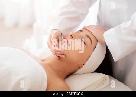 Masseuse Lady Macht Gesichts-Lifter Massage Für Indianerin Im Spa Salon Stockfoto