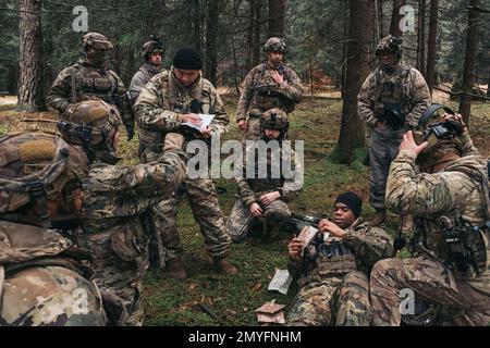 Hohenfels, Bayern, Deutschland. 1. Februar 2023. USA Soldaten, die dem 2D. Kavallerie-Regiment zugeteilt sind, stellen während Dragoon Ready 23 im Joint Multinational Readiness Center (JMRC) in Hohenfels, Deutschland, im Februar simulierte Verletzungsberichte bereit. 1, 2023. Die ÜLG des JMRC geben den Schulungseinheiten während der Übungen Feedback und tauschen Erfahrungen aus, um die Leistung und Fähigkeiten zu verbessern. Dragoon Ready 23 wurde entwickelt, um die Bereitschaft des Regiments zu gewährleisten und das Regiment in seinen missionskritischen Aufgaben zur Unterstützung eines einheitlichen Landeinsatzes zu Schulen, um seine Kenntnisse zu verbessern und die Interoperabilität zu verbessern Stockfoto