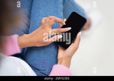 Weibliche Hände halten Handy mit leerem Bildschirm, Modell Stockfoto