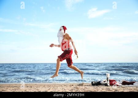 Der Weihnachtsmann hat Spaß am Strand. Weihnachtsferien Stockfoto